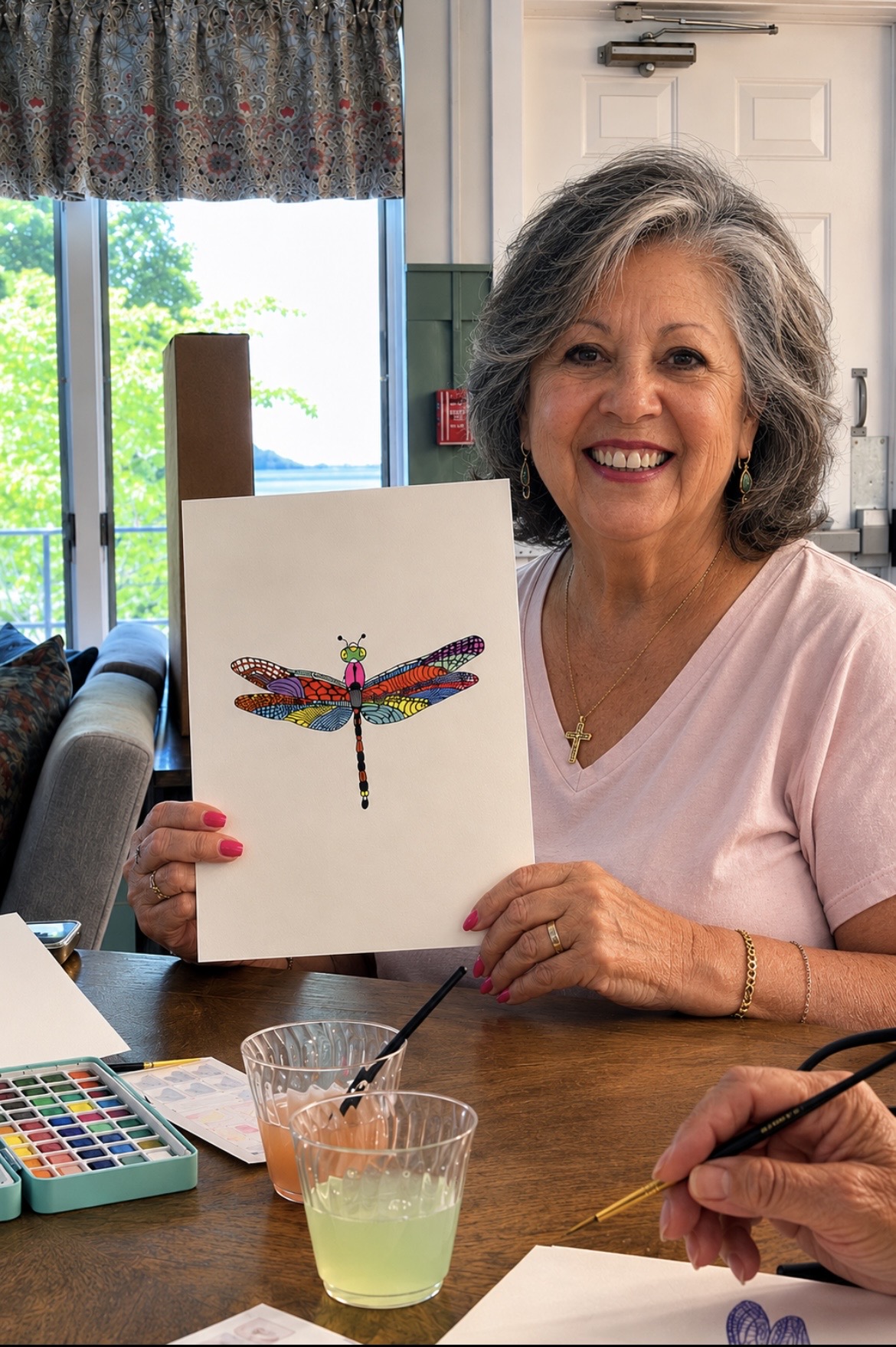 A resident showing a watercolor painting made in a community art class